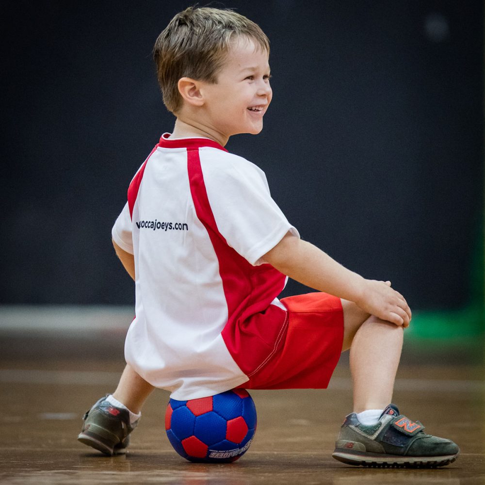 boy sitting on soccer ball